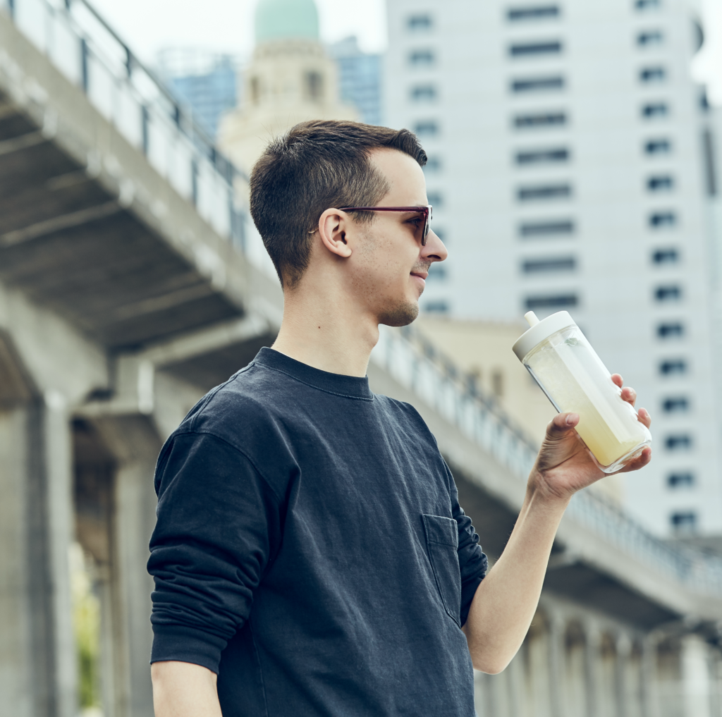 Kinto bottle 480ml muž v meste ju drží v rukách a pije